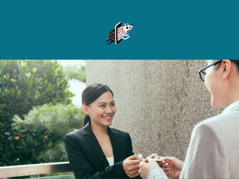 - Handing over a business card in a professional setting, illustrating networking and corporate professionalism.